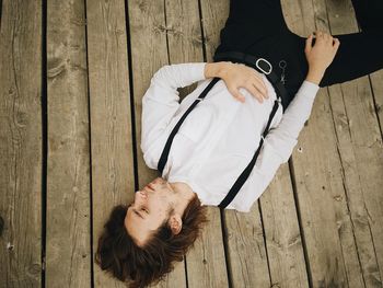 High angle view of couple lying on wooden floor