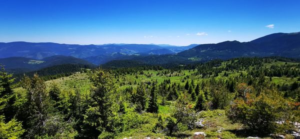 Scenic view of mountains against blue sky