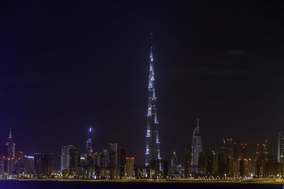 Illuminated buildings against sky at night