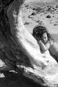 Close-up of girl leaning on tree