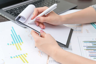 Low angle view of person using mobile phone on table