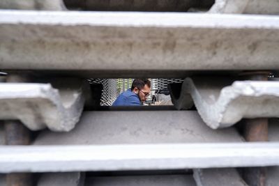 Man looking at camera while sitting on railing