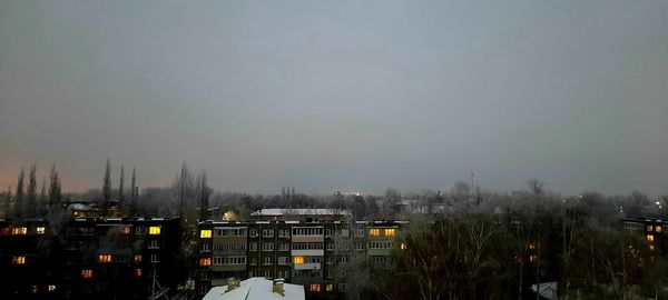 Buildings in city against sky during winter