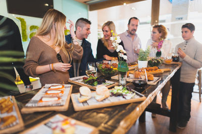 Happy friends by food at table in restaurant