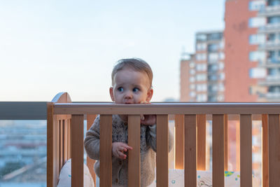 Portrait of cute girl sitting on railing