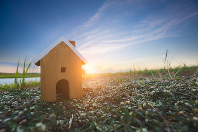 House on field against sky during sunset