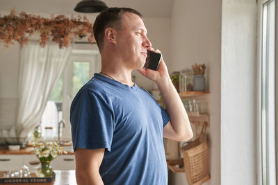 Man talking on smart phone at home