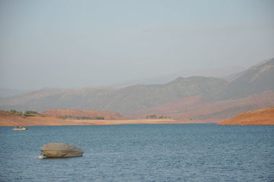 Scenic view of sea and mountains against sky