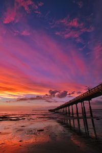 Pier over sea against sky during sunset