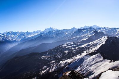 Scenic view of snowcapped mountains against blue sky