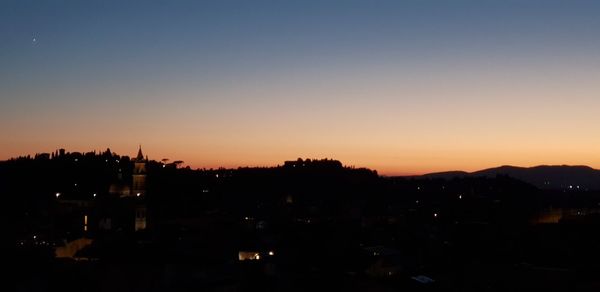 Silhouette buildings against sky during sunset