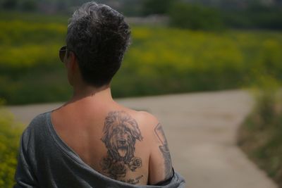 Rear view of woman with dog tattoo on back