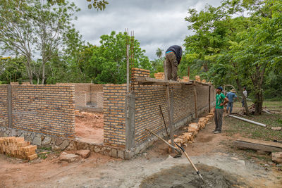 People working at construction site against sky