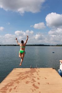 Full length of woman diving in river against sky
