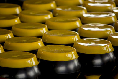 Full frame shot of black containers with yellow lids