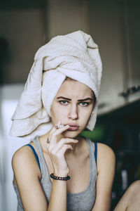 Portrait of woman holding cigarette at home