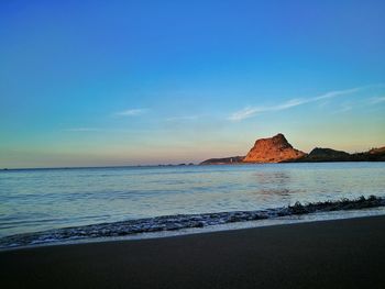 Scenic view of beach against blue sky