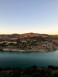 Scenic view of lake against clear sky during sunset