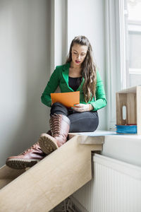 Young woman sitting on book