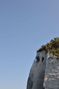 Low angle view of rock formation against clear blue sky