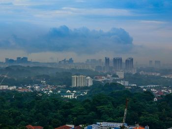 View of cityscape against cloudy sky