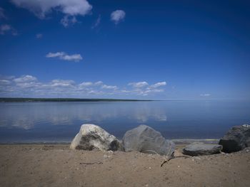 Rocks on beach against blue sky