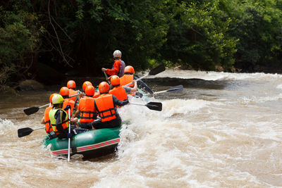 People in boat by river