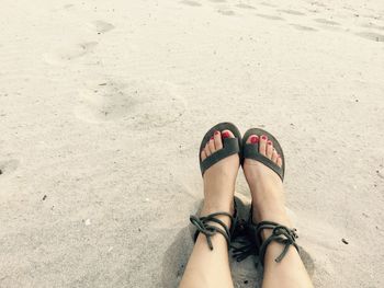 Low section of woman on sand at beach