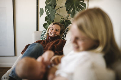 Woman watching partner breastfeed newborn baby