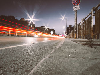 Light trails on road against sky at night