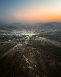 High angle view of illuminated city against sky during sunset