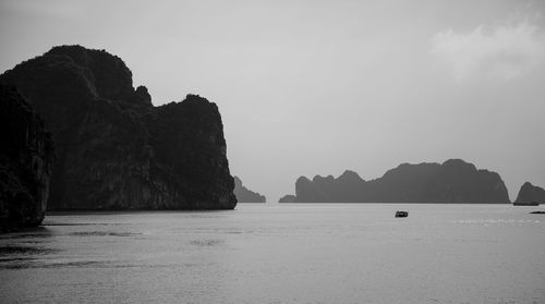 Rock formations in sea against sky