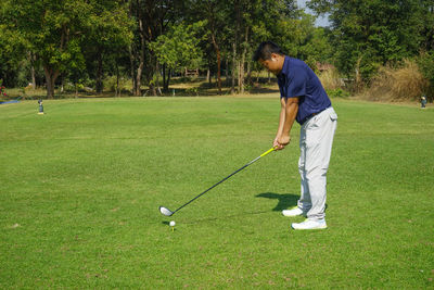 Man playing with golf ball in park