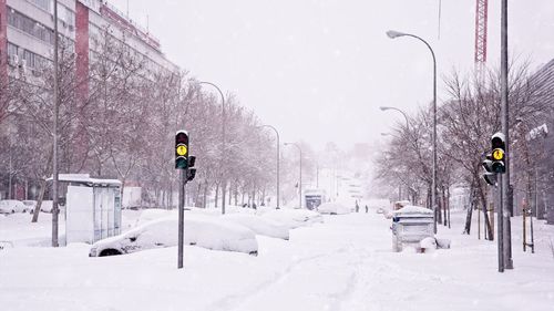 Snow covered road in city