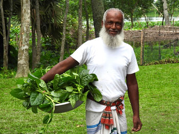 Portrait of senior man standing on field