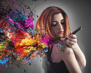 Portrait of young woman holding colorful painting
