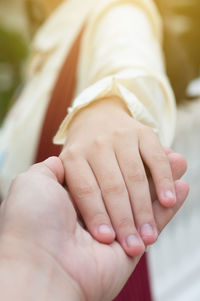 Midsection of couple holding hands