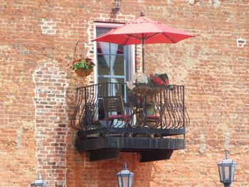 Red umbrella against brick wall