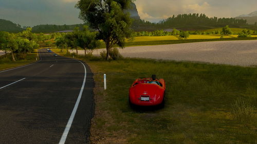 Red car on road by landscape against sky