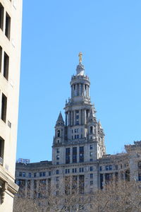 Low angle view of buildings against clear blue sky