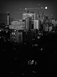 Modern buildings in city against sky at night