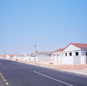 Cars on road against clear blue sky