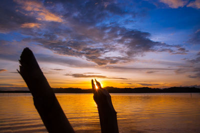 Silhouette person against orange sky during sunset