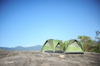 Tent on field against clear blue sky