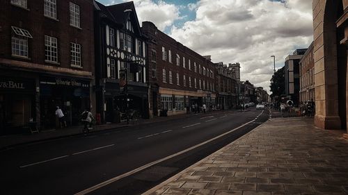 Street amidst buildings against sky in city