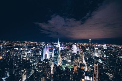 Illuminated cityscape against sky at night