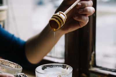 Cropped hand holding honey dipper