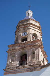 Low angle view of bell tower against blue sky