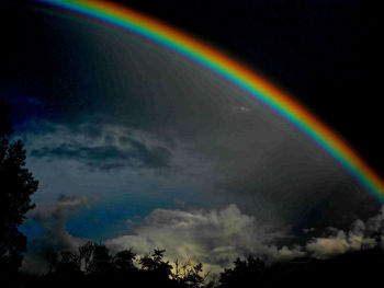 Low angle view of rainbow against cloudy sky