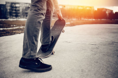 Low section of man skateboarding on road